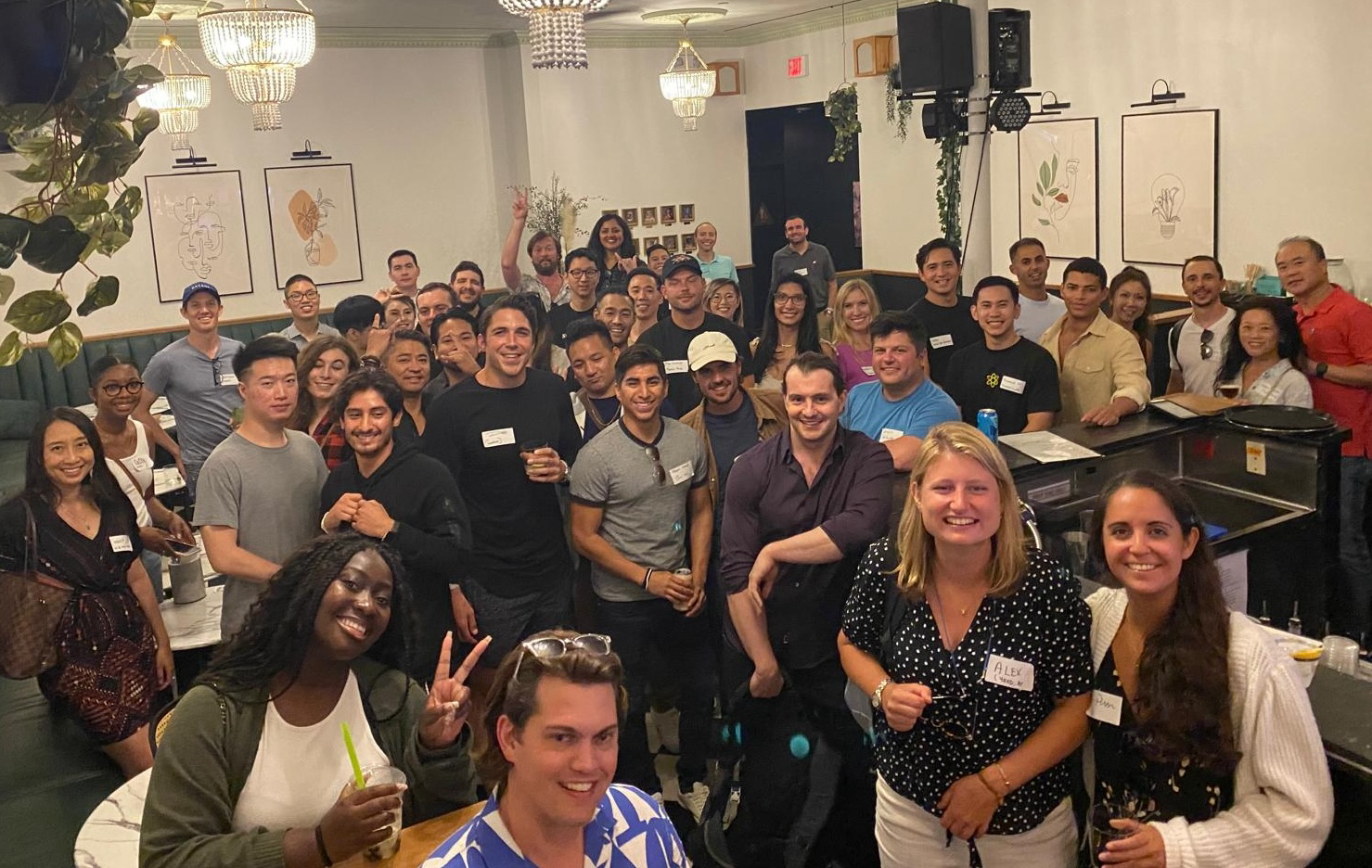 A large, diverse group of colleagues and community members gathered together at an indoor social event.